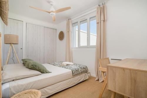 une chambre avec un lit et un ventilateur de plafond dans l'établissement Pomègues Large bright T3 and design, à Marseille