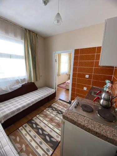 a kitchen with a stove and a bed in a room at Özmert otel in Antalya