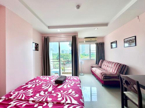 une chambre avec un lit, un canapé et une fenêtre dans l'établissement Beach 7 Condo Pattaya 11, à Jomtien Beach