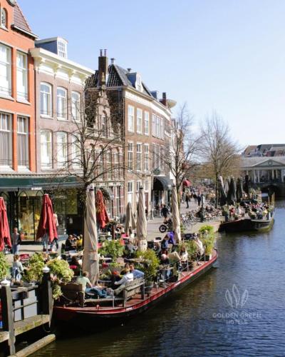 a group of people sitting on barges in a canal at Tulip Inn Leiden Centre in Leiden