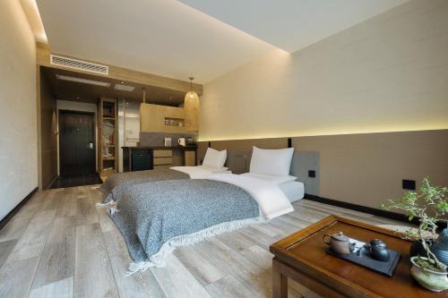 a bedroom with two white beds and a table at 青城山坐忘森林疗愈酒店 in Dujiangyan