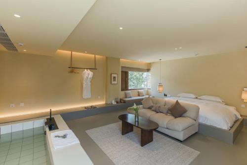 a bedroom with a bed and a couch and a table at The Long Circle House in Yanqing