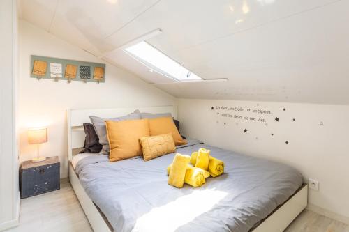 une chambre avec un grand lit avec des oreillers jaunes dans l'établissement Homelivia, ATTIC ROOM -Mansardé sous les toits de Nice, à Nice