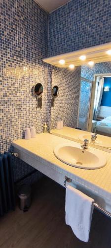 une salle de bain avec un lavabo et un miroir dans l'établissement Hôtel Le Boïate, à Arès
