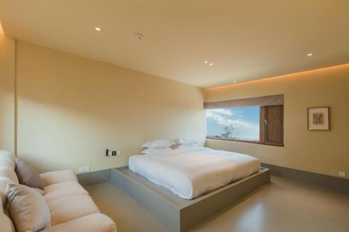 a bedroom with a bed and a couch and a window at The Long Circle House in Yanqing