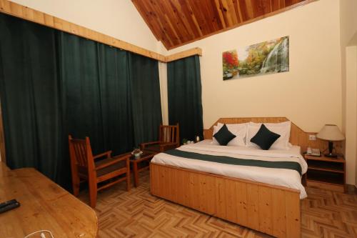 a bedroom with a bed with green drapes at Hotel Premium Mareema Near Beas River - BEST HOTEL IN MANALI in Manāli