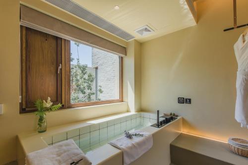 a bathroom with a window and a tub and a sink at The Long Circle House in Yanqing