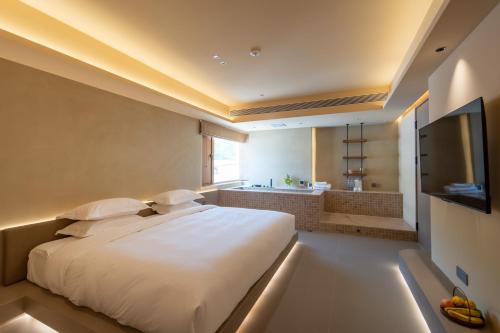 a bedroom with a large white bed and a television at The Long Circle House in Yanqing