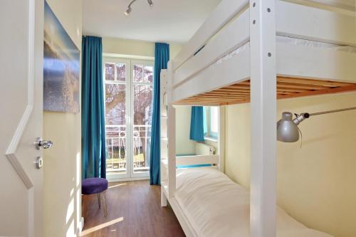 a bedroom with a bunk bed with blue curtains at Villa Seepferdchen Wohnung 08 in Kühlungsborn