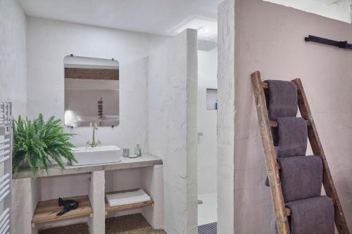 une salle de bain avec un lavabo et un miroir dans l'établissement L'Atelier, à Béziers