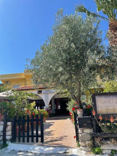 a tree in front of a building with flowers at Liros in Kamiros