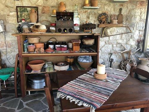 a room with a table and shelves filled with items at Liros in Kamiros