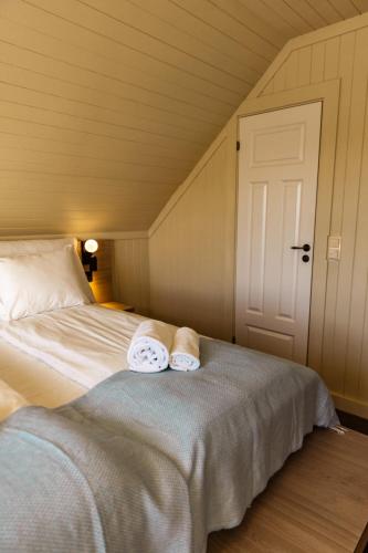 a bedroom with a bed with towels on it at Skata Hotel Henningsvær in Henningsvær