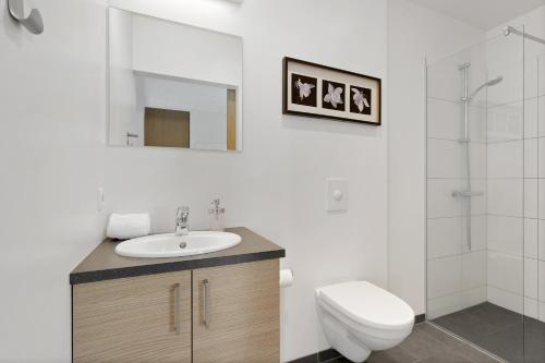a bathroom with a sink and a toilet and a mirror at Blue Mountain Apartments by Heimaleiga in Reykjavík