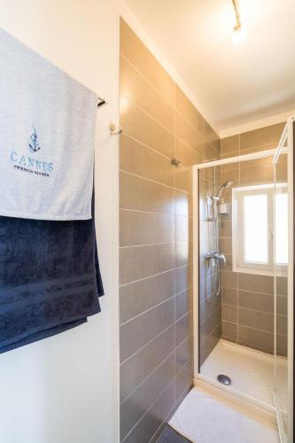 une salle de bain avec une douche avec une porte vitrée dans l'établissement Les voiles des Régates, à 5 minutes du centre à pied, 15 minutes de la mer, à Cannes