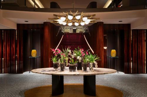 a room with a table with flowers on it at Sheraton Lake Como Hotel in Como