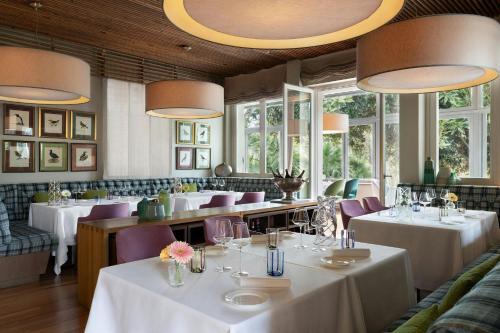 a restaurant with white tables and purple chairs at Sheraton Lake Como Hotel in Como
