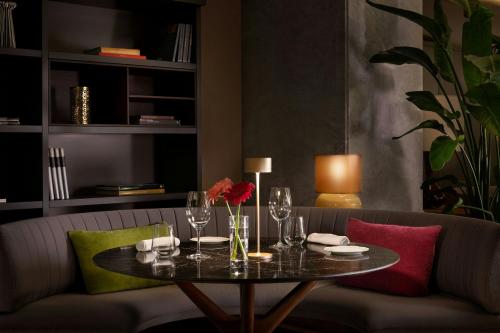 a table with wine glasses and flowers on a couch at Sheraton Lake Como Hotel in Como