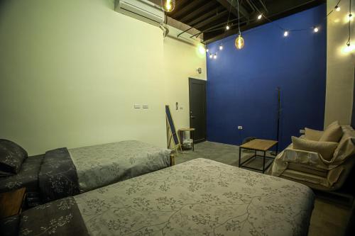 a room with two beds and a blue wall at 小島月光民宿 Moonlit Isle in Green Island