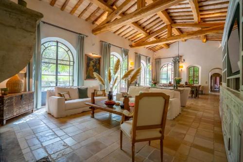 Elle comprend un salon doté d'un mobilier blanc et d'un plafond en bois. dans l'établissement Villa Vynasa, à Ramatuelle