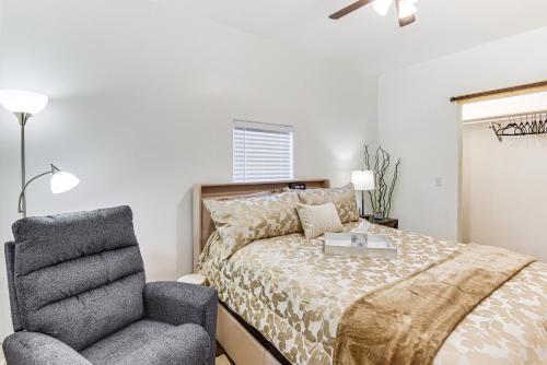 a bedroom with a bed and a chair at 1 Mi to Tulsa Arts District Updated Home with Deck! in Tulsa