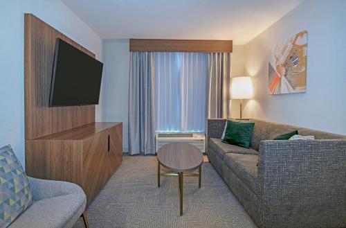a living room with a couch and a flat screen tv at Holiday Inn Hotel and Suites-Kamloops by IHG in Kamloops