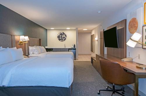 a hotel room with two beds and a desk and a computer at Holiday Inn Hotel and Suites-Kamloops by IHG in Kamloops