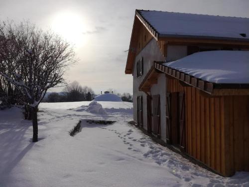 a snow covered house with footprints in the snow at Gîte 'Les Ursules', 2 à 6 personnes in Le Barboux