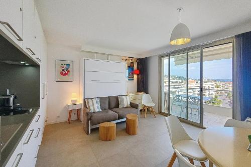 un salon avec un canapé et une table dans l'établissement HENRI CAMILLE REAL ESTATE -ARMOR - Sea view big terrace sunny 1 bedroom, à Cannes