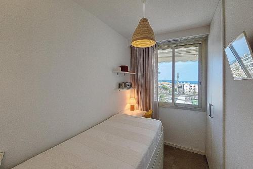 une chambre blanche avec un lit et une fenêtre dans l'établissement HENRI CAMILLE REAL ESTATE -ARMOR - Sea view big terrace sunny 1 bedroom, à Cannes