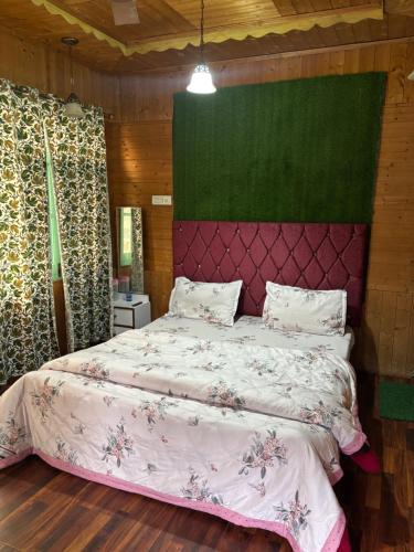 a bedroom with a bed and a green wall at Dal Fog Guest House in Srinagar