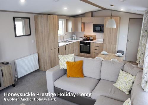 ein Wohnzimmer mit Couch und Küche in der Unterkunft Golden Anchor Holiday Park in Chapel Saint Leonards