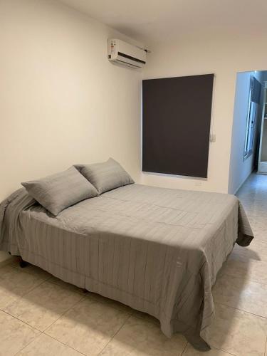 a bed in a room with a flat screen tv at Torre Kalinka dos dormitorios pleno centro 6 personas in Villa Carlos Paz