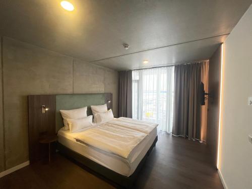 a bedroom with a bed and a large window at DX Apartments in Berlin