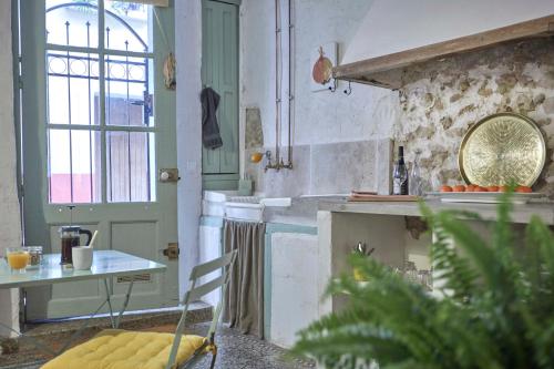 une cuisine avec un comptoir et une table avec une chaise dans l'établissement L'Atelier, à Béziers