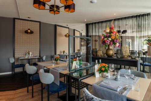a dining room with tables and chairs and flowers at Tulip Inn Leiden Centre in Leiden