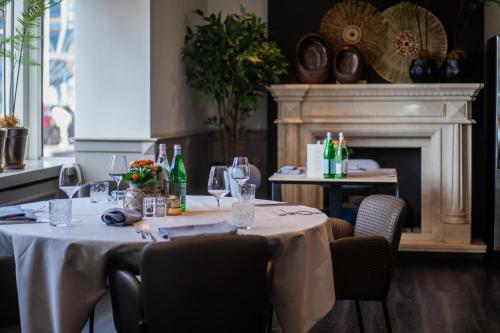a dining room with a table with wine glasses and a fireplace at Tulip Inn Leiden Centre in Leiden