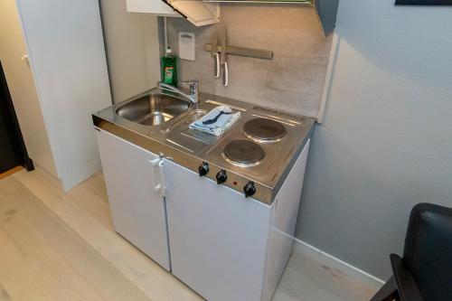 a small kitchen with a sink and a stove at Pensjonat Jarlen in Trondheim