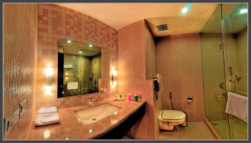 ein Badezimmer mit einem Waschbecken, einem WC und einem Spiegel in der Unterkunft The Retreat in Agra
