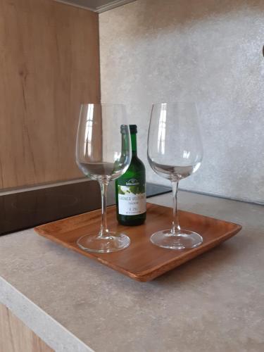 two glasses and a bottle of wine on a wooden tray at Vila Johanka & Apartments in Český Krumlov