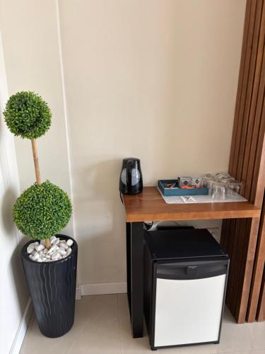 a desk with a potted plant next to a trash can at Sweet69apartments JP in Niš