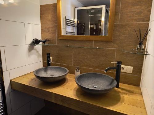 two sinks on a wooden counter in a bathroom at B&B La Belle Histoire Laforêt in Laforêt