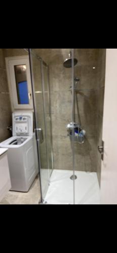 une douche en verre dans une cuisine équipée d'un lave-linge et d'un sèche-linge dans l'établissement Appartement lumineux, à Calvi