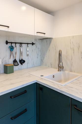 une cuisine avec des armoires bleues et un évier dans l'établissement Homelivia Av Jean Médecin, à Nice