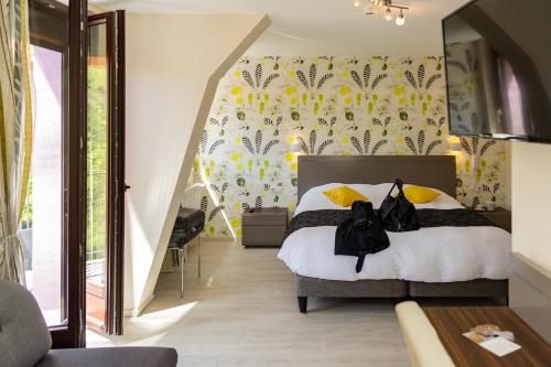 1 dormitorio con 1 cama con papel pintado de color amarillo y blanco en Logis Hotel Des Vosges, en Sewen