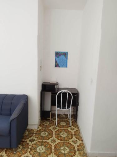 a living room with a blue couch and a desk at Apto tipo Casa 10 com 2 quartos bem grande Praia da Costa Centro Ar Condicionado Internet Mobiliado Geladeira Fogao TV in Vila Velha