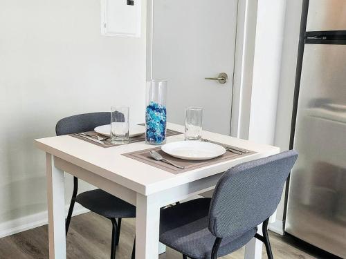 a white table with two chairs and a plate and glasses at CN Tower Luxe Suites - Prime Downtown Location in Toronto