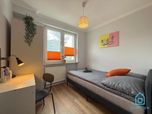 a bedroom with a bed and a desk and two windows at Spongebob Room 10 Min to Old Town Gdańsk,PKP & Shopping Mall in Gdańsk