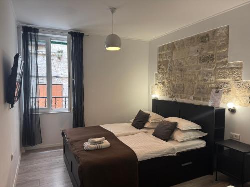 a bedroom with a large bed in front of a window at Palace Wall Residences in Split