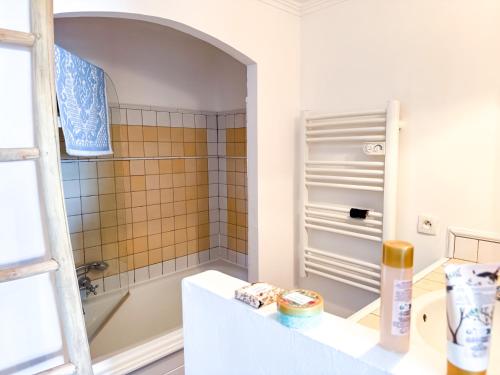 une salle de bain avec une baignoire et un lavabo dans l'établissement Appartement rénové à Grimaud dans le Golfe de Saint-Tropez - Les Restanques, à Grimaud